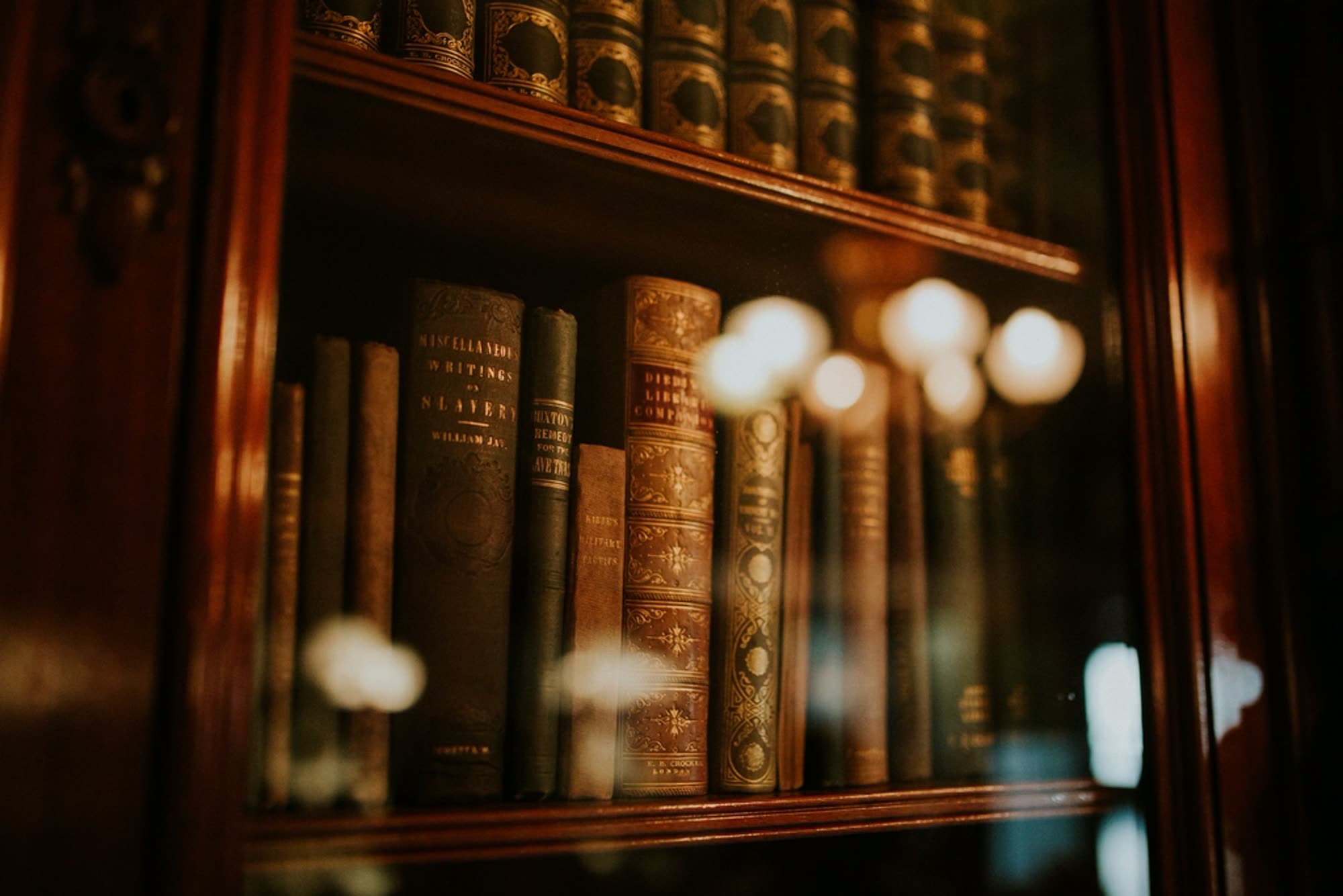 Old leather-bound law books behind glass in a wooden bookcase
