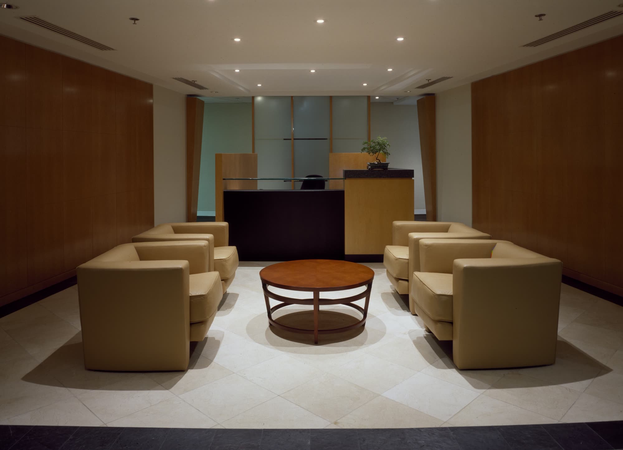A calm lobby with wood panelling and cream armchairs